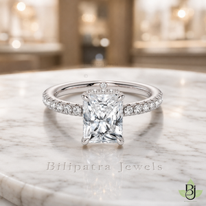 Jewelry Photography Specifications. Visual Style & Composition. Produce ultra-realistic macro photography of the uploaded Product, capturing every detail with precision. Set the Product on a table White Marble surface to achieve a refined and timeless luxury aesthetic. Utilize background bokeh mode to simulate professional jewelry showroom scenes. Maintain absolute fidelity to the reference file regarding product design, diamond details, and camera angles. Technical Requirements & Branding. Output image quality must be exactly 2000 x 2000 pixels. Metal Color Change to White Gold.