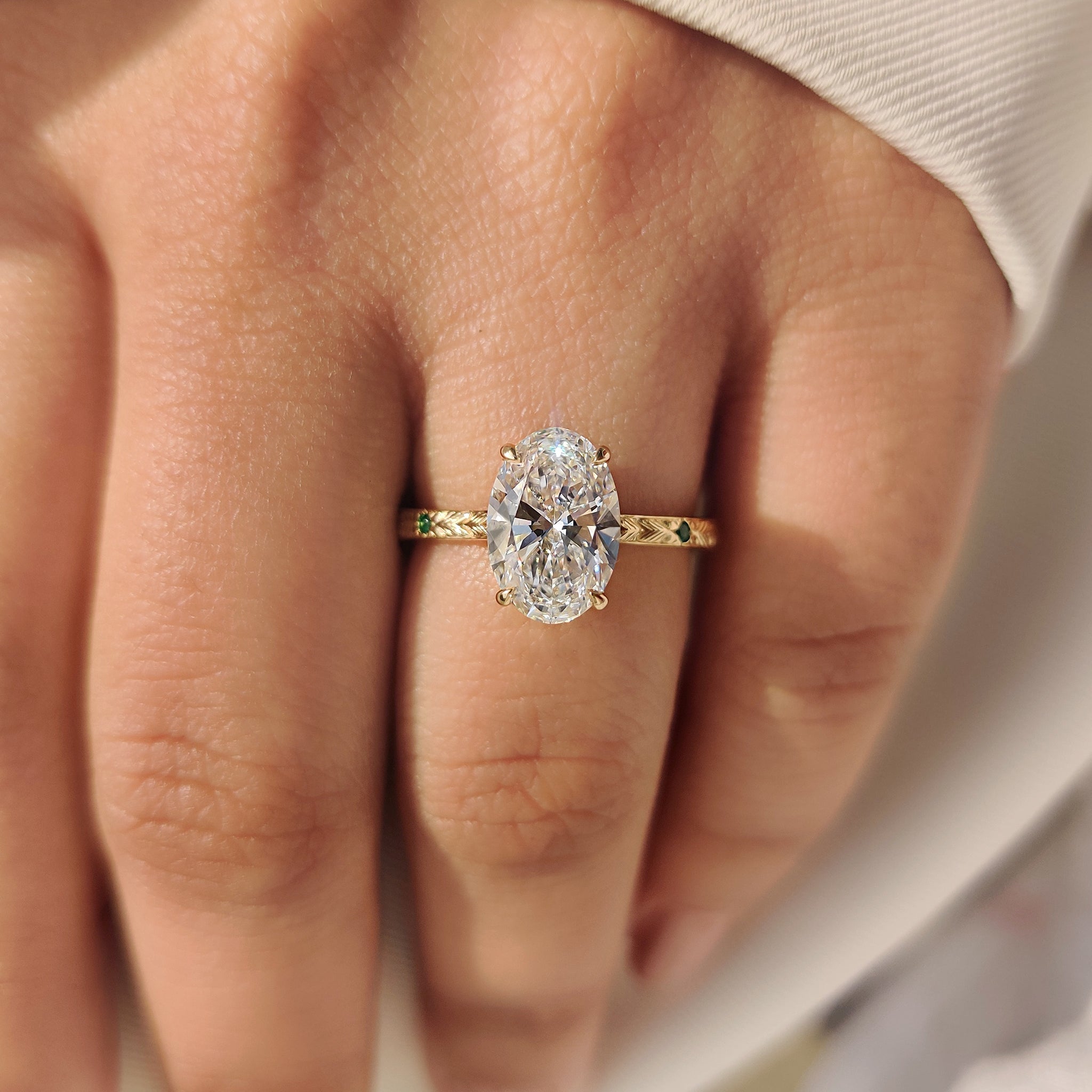Oval Cut Art Deco Diamond Ring with Two Emerald Side Gemstones