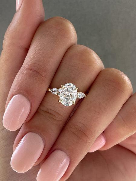 1.6ct Oval cut moissanite Trilogy with Round and Pear cluster engagement rings