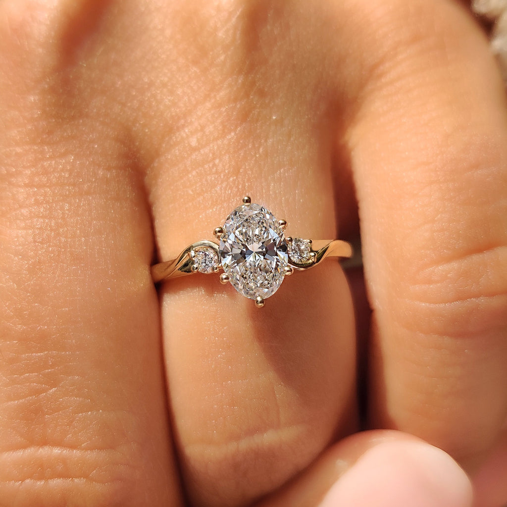 Three Stone Style Oval Cut Engagement Ring with Round Side Stone