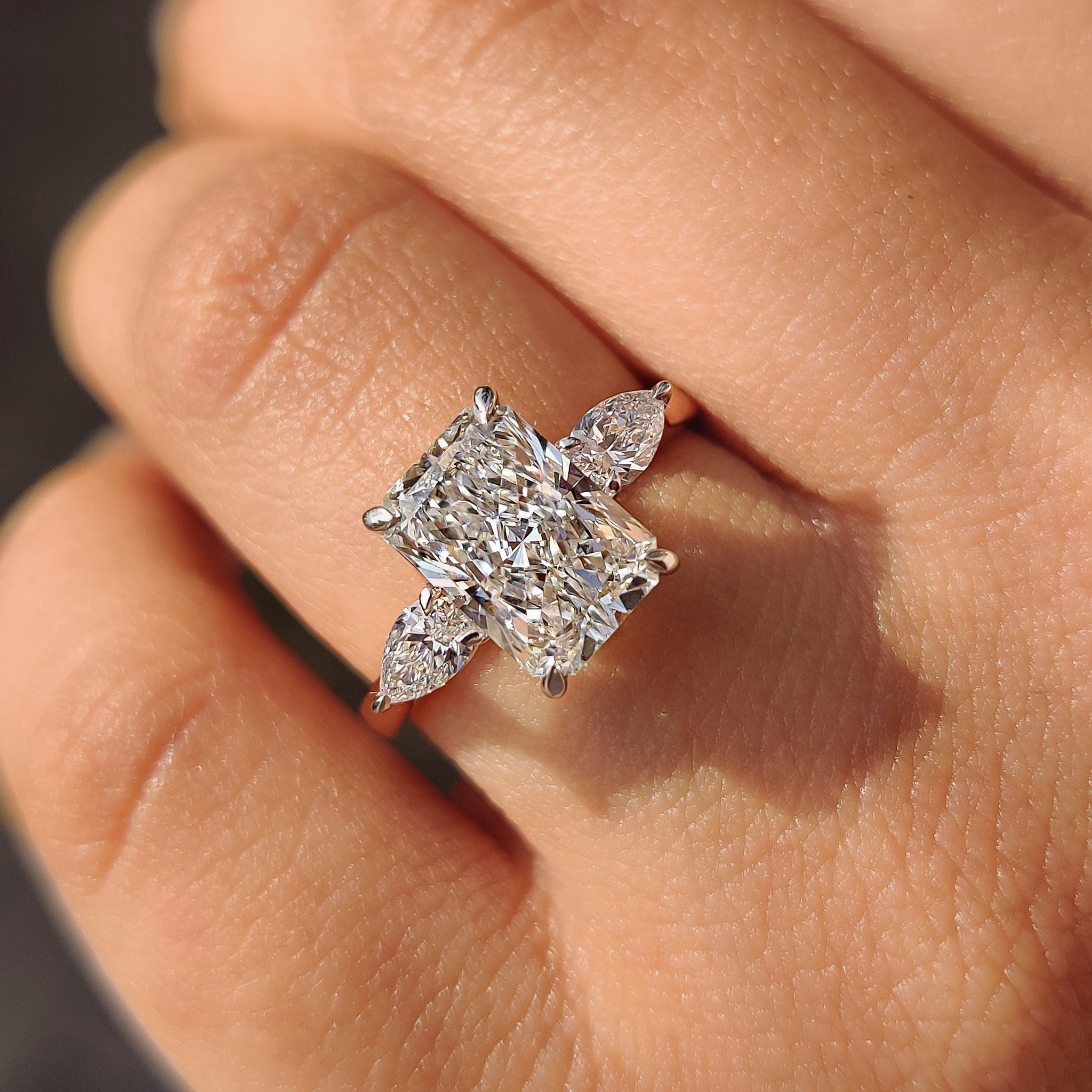 Two Tone Radiant Cut Diamond Ring With Pear Side Stones