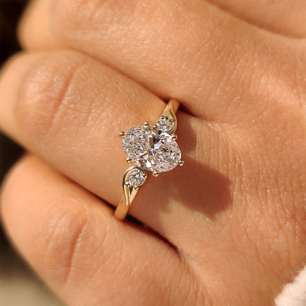 Three Stone Style Oval Cut Engagement Ring with Round Side Stone