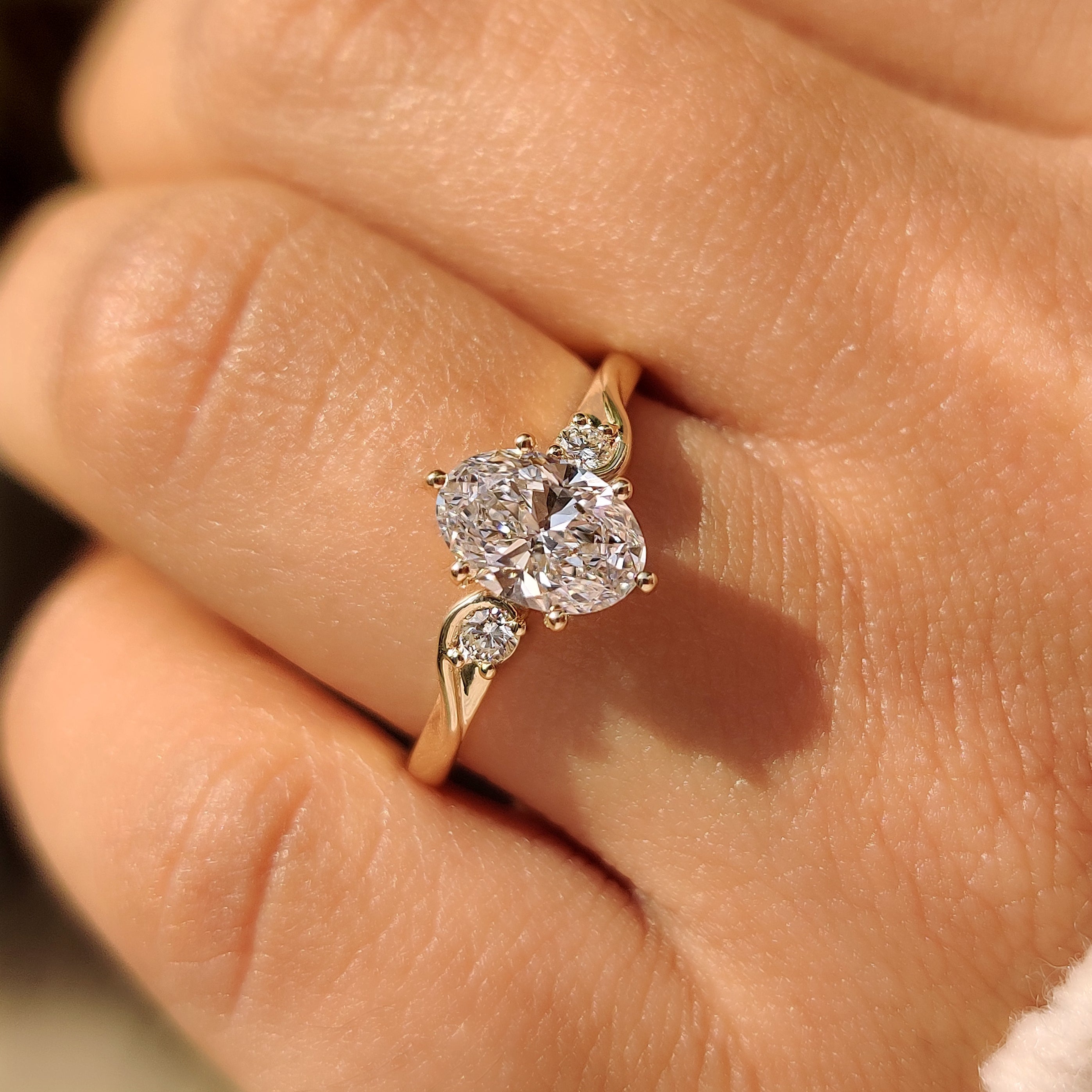 Three Stone Style Oval Cut Engagement Ring with Round Side Stone