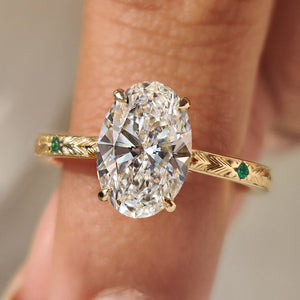 Oval Cut Art Deco Diamond Ring with Two Emerald Side Gemstones