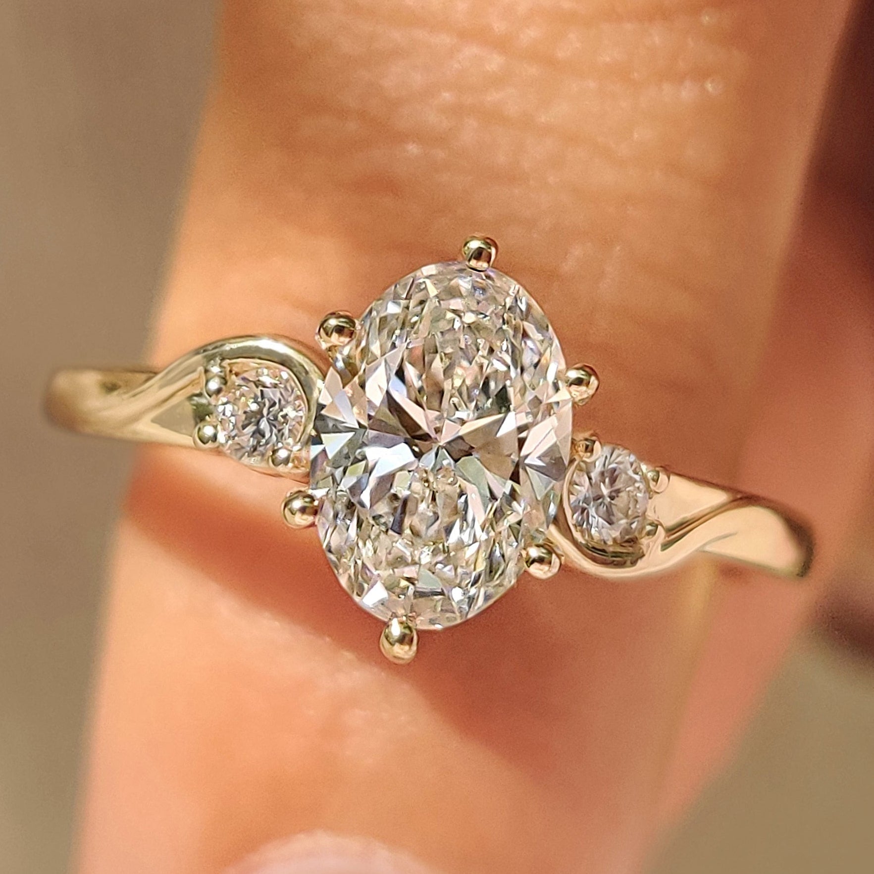 Three Stone Style Oval Cut Engagement Ring with Round Side Stone Main image