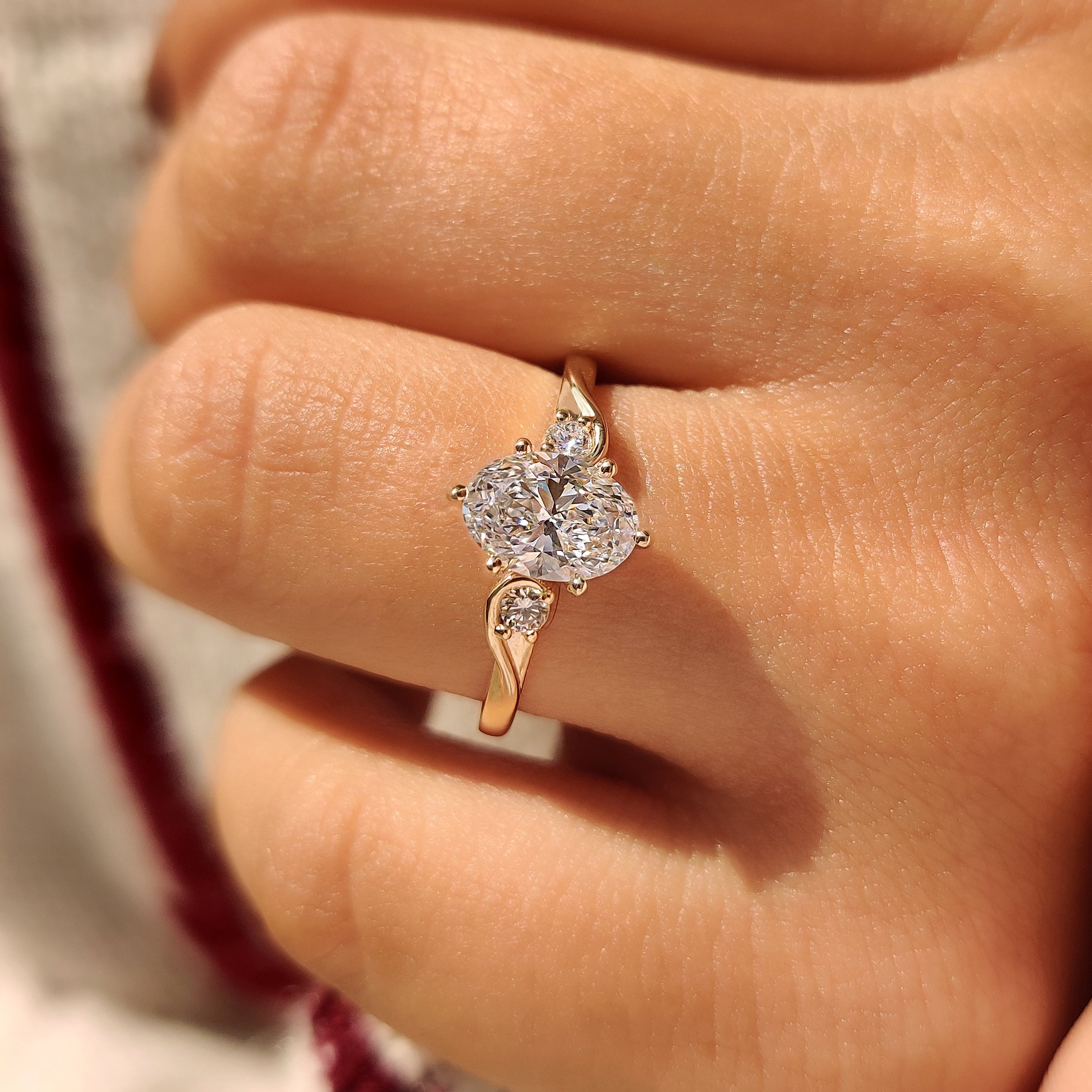 Three Stone Style Oval Cut Engagement Ring with Round Side Stone
