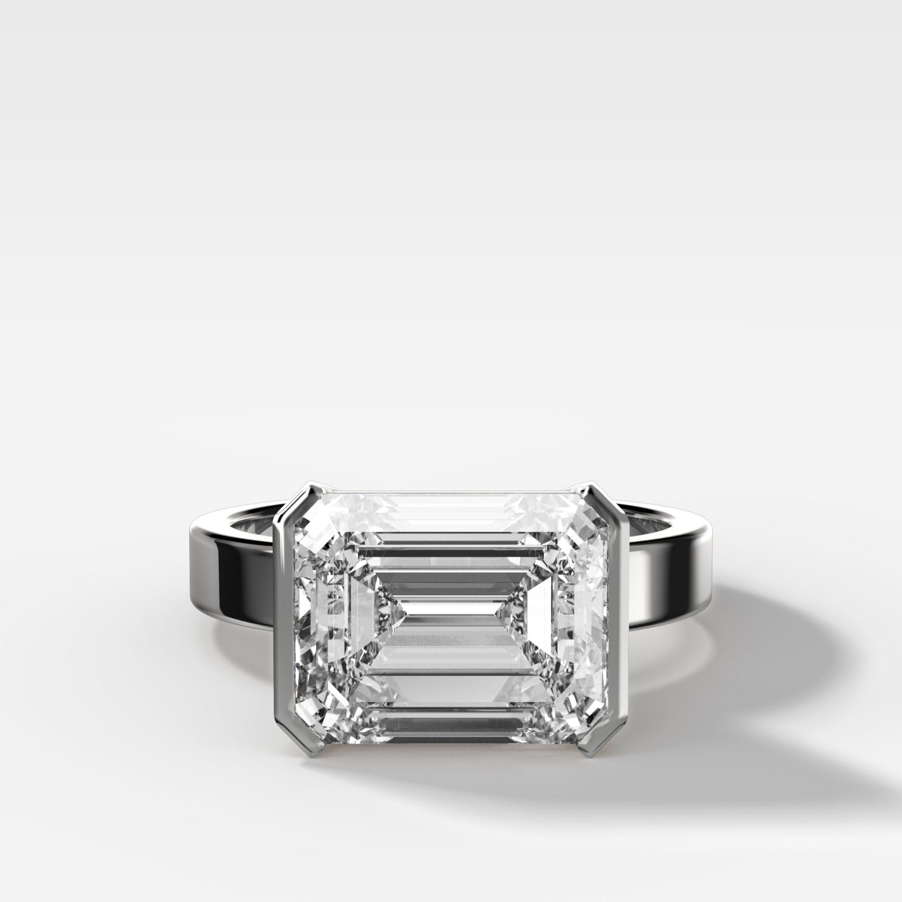 Finest Half Bezel Solitaire Engagement Ring With East West Emerald Cut Diamond