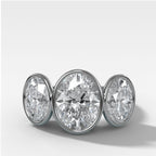 Penumbra Bezel Triad Engagement Ring With Oval Cut Diamonds