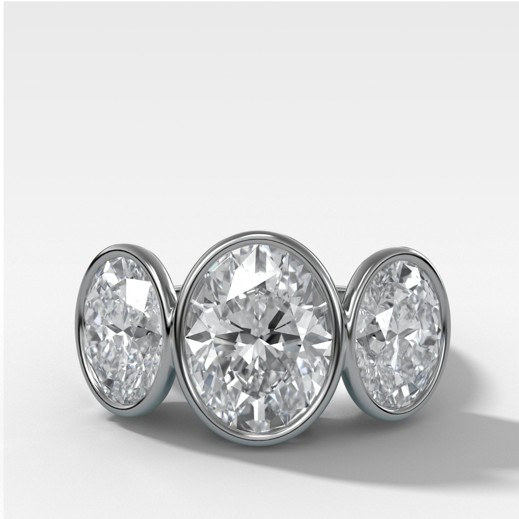 Penumbra Bezel Triad Engagement Ring With Oval Cut Diamonds
